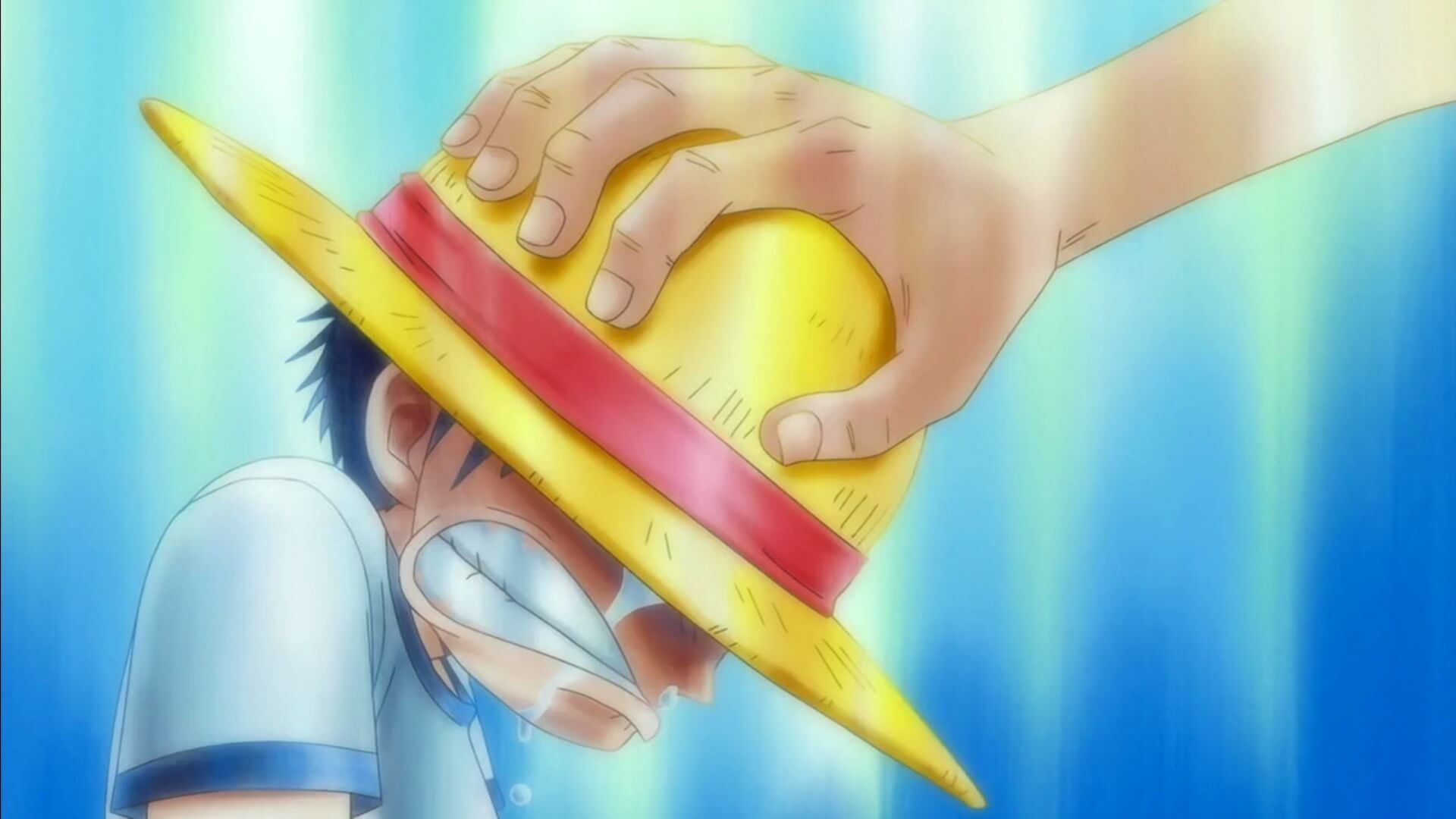 Shanks entregando el sombrero de paja a Luffy cuando era niño, escena icónica de One Piece